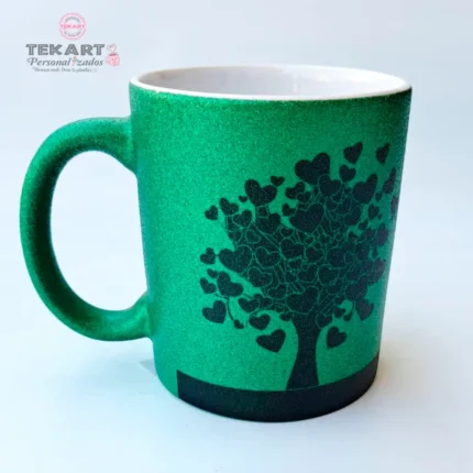 Imagem de uma caneca com glitter verde, estampa de árvore em preto e a frase 'Nenhuma beleza brilha mais que um coração bom