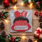 Lembrancinha corporativa de Natal personalizada com vestido de Mamãe Noel em papel fotográfico, xuxinha de cabelo, mensagem de fim de ano, embalagem individual e personalização com telefone e Instagram da empresa.